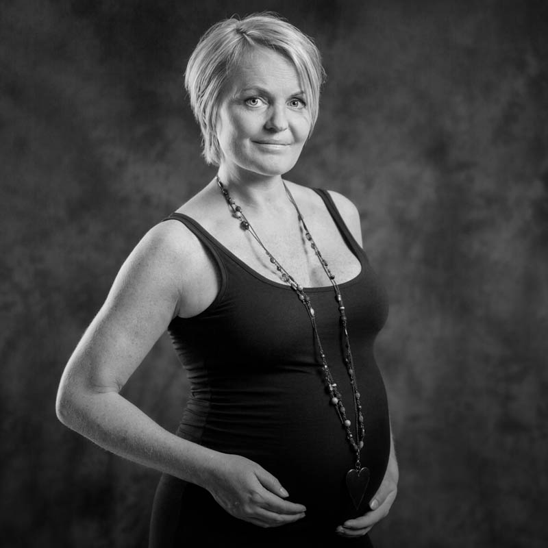 lille familie i afstemt lyst tøj til fotosession i studiet