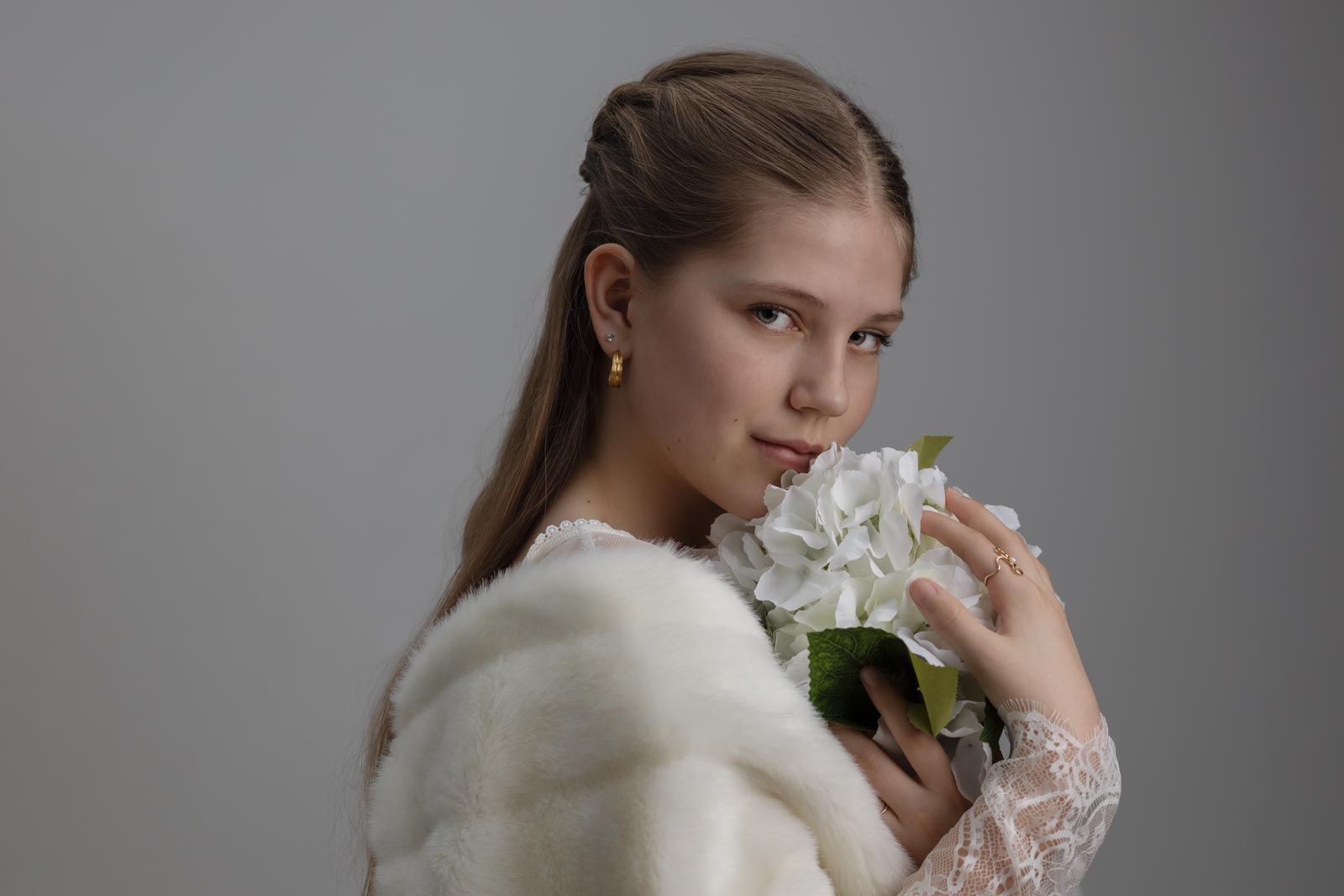 en pige holder en blomst foran sig