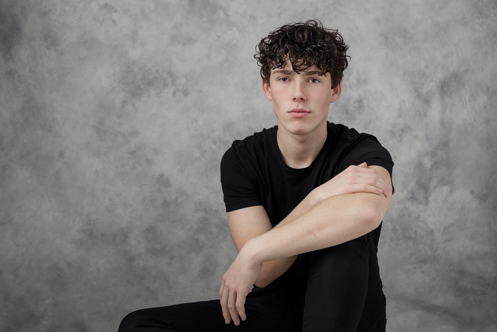 Ung teenager sidder på gulvet i fotostudiet
